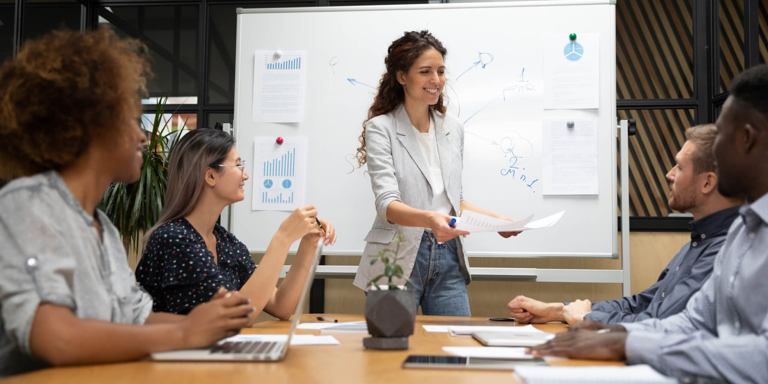 Diverse staff and business trainer starting seminar giving learning material